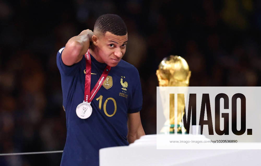 Doha, Qatar, 18th December 2022. Kylan Mbappe of France sneaks a lot athlete World Cup trophy as he collects his losers medal during the FIFA World Cup, WM, Weltmeisterschaft, Fussball 2022 match at Lusail Stadium, Doha. Picture credit should read: David Klein Sportimage . SPI-2101-0232