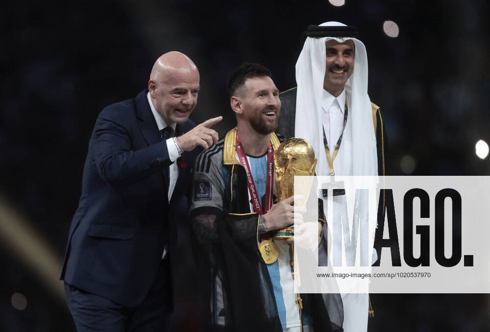 Lionel Messi (C) from Argentina poses with the World Cup trophy together with FIFA President Giovanni Vincenzo (L) and the Emir of the State of Qatar in the final of the FIFA World Cup, WM, Weltmeisterschaft, Fussball soccer tournament between Argentina and France at Lusail stadium in Lusail, Qatar, 18 December 2022. Soccer World Cup 2022: Argentina - France !ACHTUNG: NUR REDAKTIONELLE NUTZUNG!