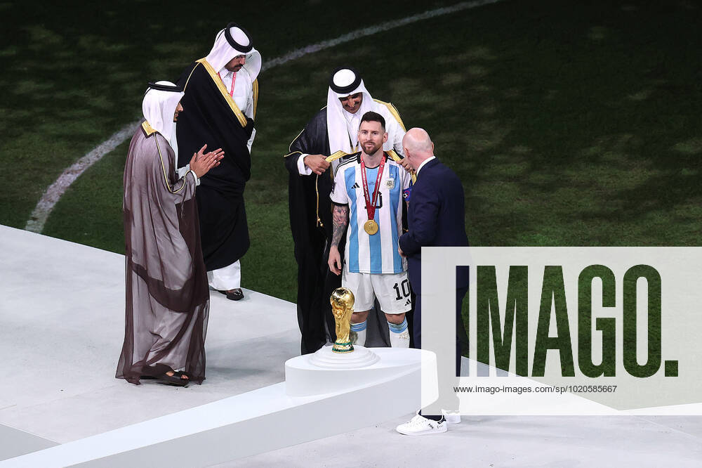 The Final : FIFA World Cup, WM, Weltmeisterschaft, Fussball 18 December 2022, Lusail City - FIFA World Cup Qatar 2022 - Final - Argentina v France - Lionel Messi of Argentina is dressed in a Bisht by the Sheikh Tamin bin Hamad Al Thani, Amir of Qatar as FIFA President Gianni Infantino watches - Photo: Charlotte Wilson Offside. Doha Qatar