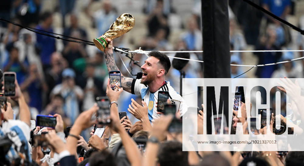 Fussball, Herren, Saison 2022 23, WM in Katar, Finale, Argentinien - Frankreich (2:2, 3:3 n. V, 4:2 i. E.) im Lusail Iconic Stadium in Lusail, Lionel Messi (Argentinien) mit Pokal, er wird lange nach Spielende im Berreich hinter dem Tor auf Schultern getragen, er wird von Fans mit dem Handy fotografiert und gefilmt, Jubel nach dem Abpfiff, 18.12. 2022,