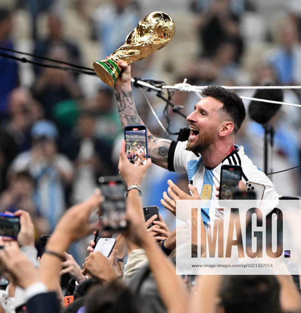 Fussball, Herren, Saison 2022 23, WM in Katar, Finale, Argentinien - Frankreich (2:2, 3:3 n. V, 4:2 i. E.) im Lusail Iconic Stadium in Lusail, Lionel Messi (Argentinien) mit Pokal, er wird lange nach Spielende im Berreich hinter dem Tor auf Schultern getragen, er wird von Fans mit dem Handy fotografiert und gefilmt, Jubel nach dem Abpfiff, 18.12. 2022,