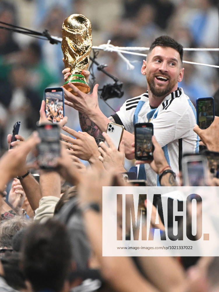 Fussball, Herren, Saison 2022 23, WM in Katar, Finale, Argentinien - Frankreich (2:2, 3:3 n. V, 4:2 i. E.) im Lusail Iconic Stadium in Lusail, Lionel Messi (Argentinien) mit Pokal, er wird lange nach Spielende im Berreich hinter dem Tor auf Schultern getragen, er wird von Fans mit dem Handy fotografiert und gefilmt, Jubel nach dem Abpfiff, 18.12. 2022,
