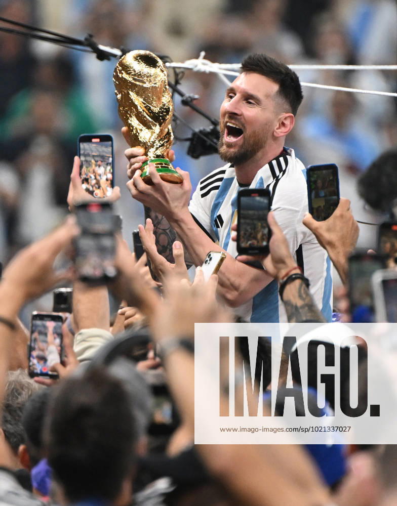 Fussball, Herren, Saison 2022 23, WM in Katar, Finale, Argentinien - Frankreich (2:2, 3:3 n. V, 4:2 i. E.) im Lusail Iconic Stadium in Lusail, Lionel Messi (Argentinien) mit Pokal, er wird lange nach Spielende im Berreich hinter dem Tor auf Schultern getragen, er wird von Fans mit dem Handy fotografiert und gefilmt, Jubel nach dem Abpfiff, 18.12. 2022,
