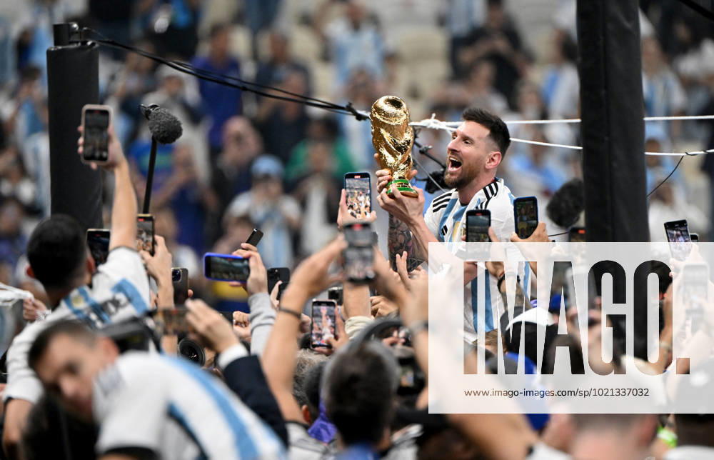 Fussball, Herren, Saison 2022 23, WM in Katar, Finale, Argentinien - Frankreich (2:2, 3:3 n. V, 4:2 i. E.) im Lusail Iconic Stadium in Lusail, Lionel Messi (Argentinien) mit Pokal, er wird lange nach Spielende im Berreich hinter dem Tor auf Schultern getragen, er wird von Fans mit dem Handy fotografiert und gefilmt, Jubel nach dem Abpfiff, 18.12. 2022,