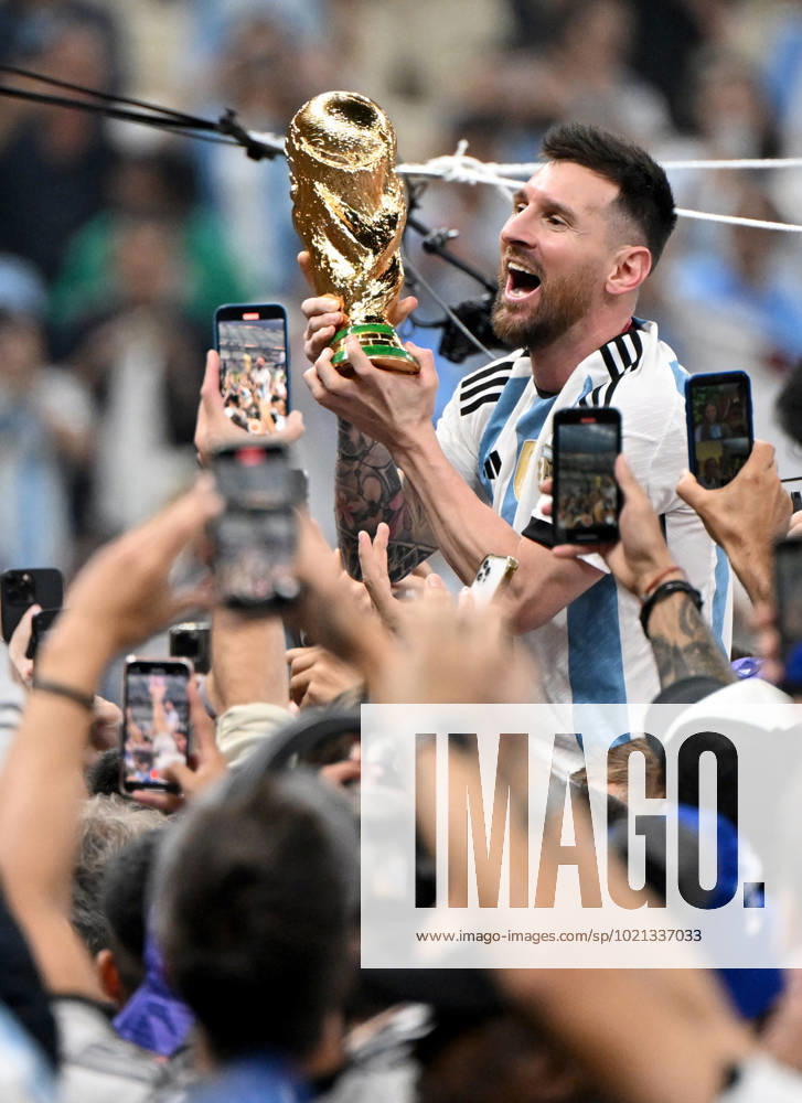 Fussball, Herren, Saison 2022 23, WM in Katar, Finale, Argentinien - Frankreich (2:2, 3:3 n. V, 4:2 i. E.) im Lusail Iconic Stadium in Lusail, Lionel Messi (Argentinien) mit Pokal, er wird lange nach Spielende im Berreich hinter dem Tor auf Schultern getragen, er wird von Fans mit dem Handy fotografiert und gefilmt, Jubel nach dem Abpfiff, 18.12. 2022,