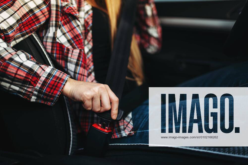 Tag der Verkehrssicherheit am 19. Juni Woman driver fastens her seat belt in the car