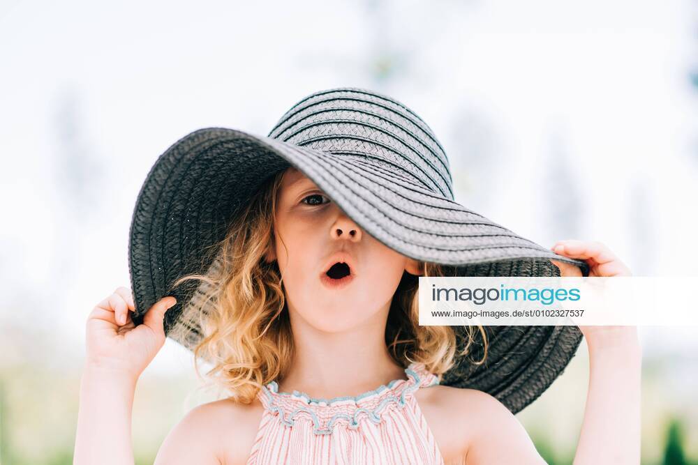 Portrait of a young girl pulling a funny expression with a sun hat on Norrtälje, Stockholm County, Sweden CR_RABE200701-430685-01 ,model released, Symbolfoto