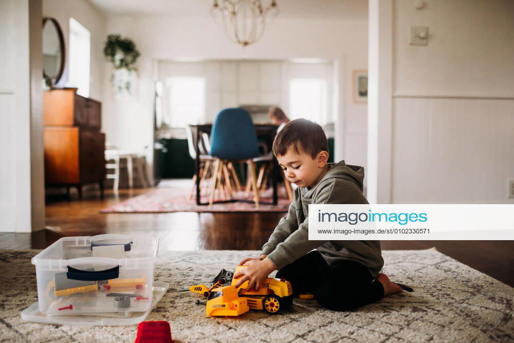 IMAGO Creative: Jahreszeit Winter, Fantasievoll drinnen spielen Toddler boy sitting inside putting together toy tractor Fort Worth, TX, United States CR_TAHI200701-413927-01 ,model released, Symbolfoto