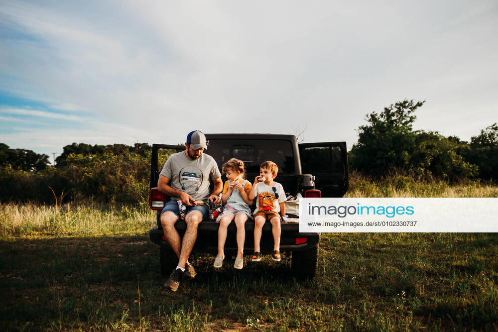 Dad and two kids having a picnic on truck tailgate Fort Worth, TX, United States CR_TAHI200701-413989-01 ,model released, Symbolfoto