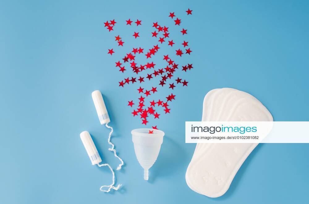 Sanitary pad, menstrual cup and tampons on blue background. Concept of feminine hygiene during menstruation.