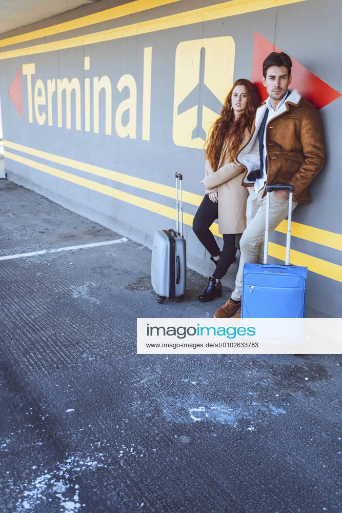 Confident business couple standing with luggage at airport terminal model released Symbolfoto EHF00432