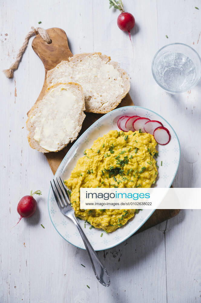 Plate of vegan scrambled eggs with chick-peas, chive, radish and bread IPF00541
