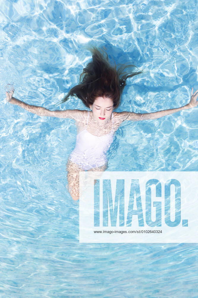 Young woman with eyed closed relaxing on swimming pool at resort during sunny day model released Symbolfoto JPTF00553