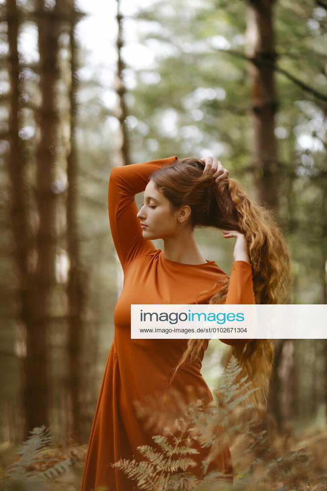 Beautiful woman with long blond hair standing in forest model released Symbolfoto TCEF00937