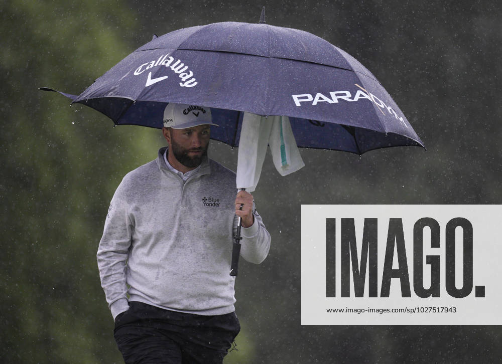 Jon Rahm protects himself from the rain at the 18th green during the rain delayed second round at the 87th Masters tournament at Augusta National Golf Club in Augusta, Georgia on Saturday, April 8, 2023. Rahm finished at 134 and in second place. AUG20230408224 BOBxSTRONG