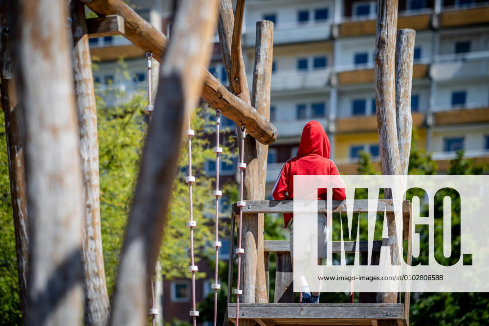 IMAGO Creative: Gesellschaft, Armut 31. Juli 2020: Leipzig (Sachsen), Stadtteil Gruenau: Ein Kind steht auf einem Spielplatz vor einem Plattenbau in Leipzig-Gruenau.
