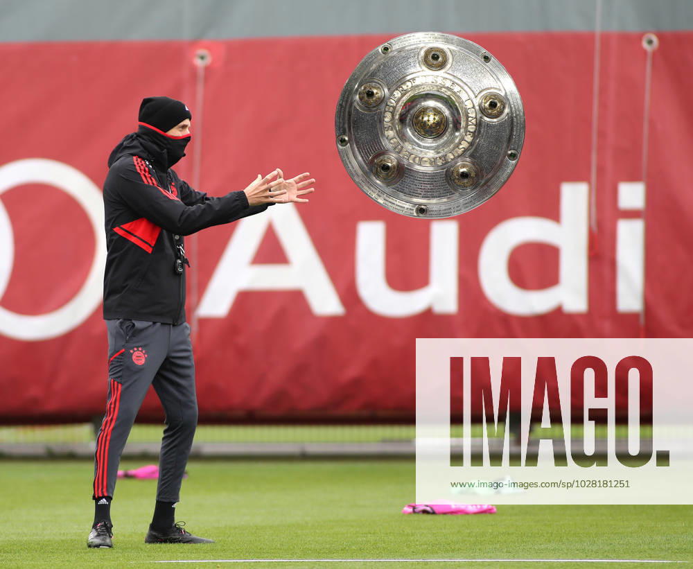 München, Deutschland 18. April 2023: Fussball, Herren, Saison 2022 2023, FC Bayern München, Säbener Strasse, Trainingsgelände, Training, Thomas Tuchel Hier eine Fotomontage, Symbolbild wie Thomas Tuchel, Trainer (FC Bayern München) die Meisterschale fängt, fangen will, dazu streckt er die Arme aus, Minimalziel
