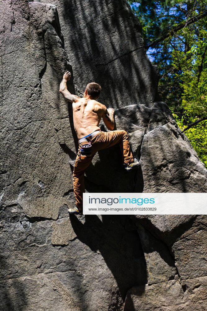 Shirtless fit climber getting to the top of the boulder Leavenworth, WA, United States CR_SEAK200722-445784-01 ,model released, Symbolfoto