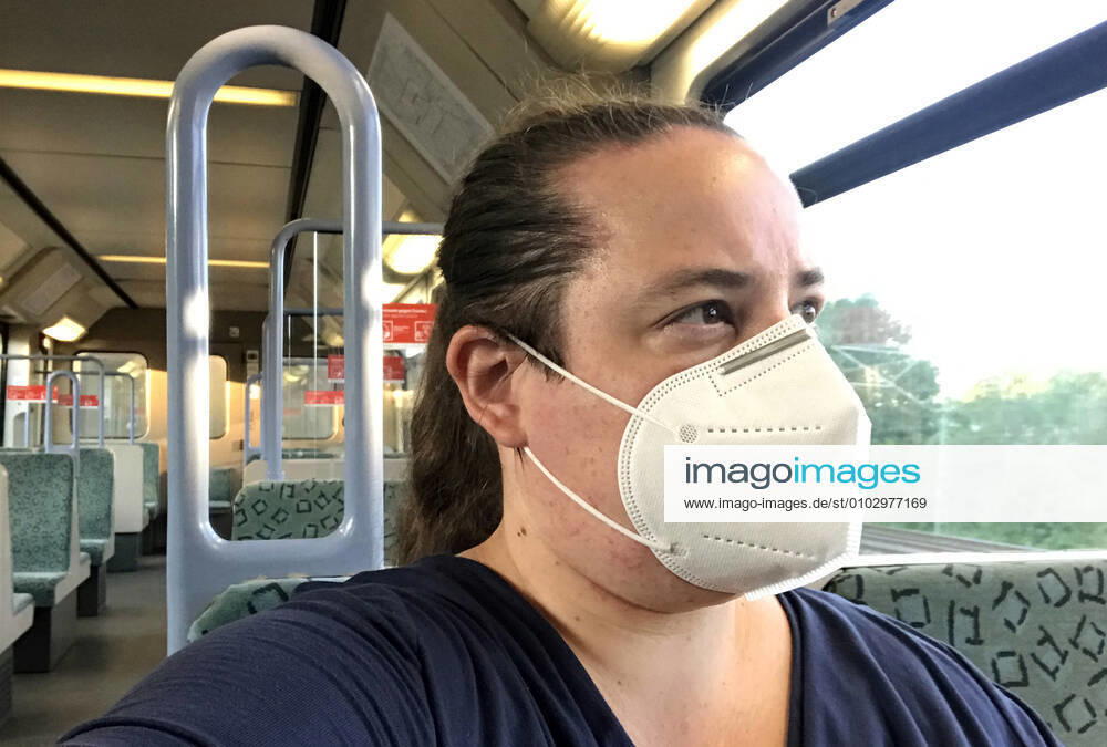 Berlin, GER - Frau in einer S-Bahn traegt in Zeiten der Coronapandemie eine Atemmaske. (MR=yes, 40-50 Jahre, Abteil, Alltag, Atemmaske, Bahn, Berlin, Coronaepidemie, Coronainfektion, Coronakrise, Coronapandemie, Coronavirus, Coronavirus SARS-CoV-2, Covid 19, Covid-19, deutsch, Deutschland, Europa, europaeisch, Fenster, FFP2, FFP2-Maske, Frau, geschuetzt, Gesellschaft, innen, Innenaufnahme, Jahreszeit, Kaukasierin, kaukasisch, Maske, Maskengebot, Maskenpflicht, Mensch, Mund-Nase-Schutz, Mund-Nasen-Schutz, Mundschutz, Mundschutzgebot, Mundschutzpflicht, Nahverkehr, oeffentlicher Personennahverkehr, OEPNV, Person, Personennahverkehr, QF, Querformat, S-Bahn, Schutz, Schutzmaske, Sommer, verpflichtend, Verpflichtung, Waggon, Westeuro