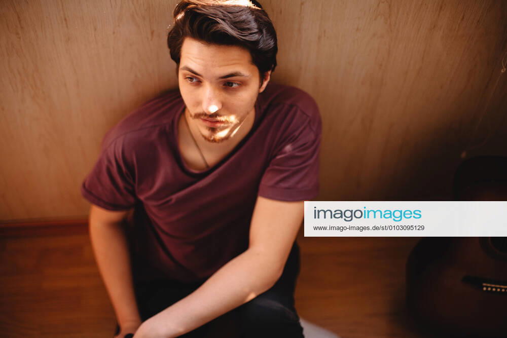 IMAGO Creative: Gesellschaft, Armut Thoughtful young man sitting on balcony floor at home CR_DMBE200812-379078-01 ,model released, Symbolfoto
