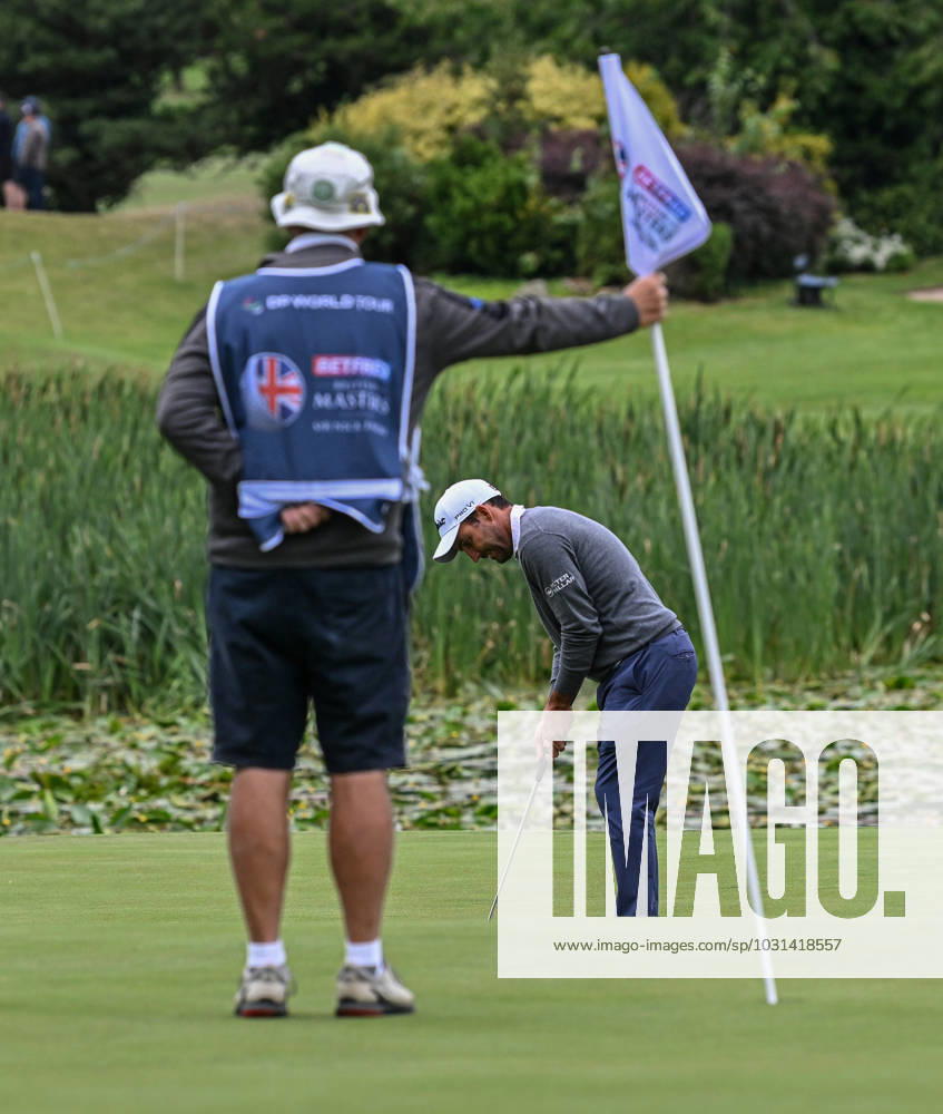 2nd July 2023; The Belfry, Sutton Coldfield, West Midlands, England: Betfred British Masters Golf, Day 4; Edoardo Molinari s caddy holds the flag while he putts ActionPlus12526237 GodfreyxPitt
