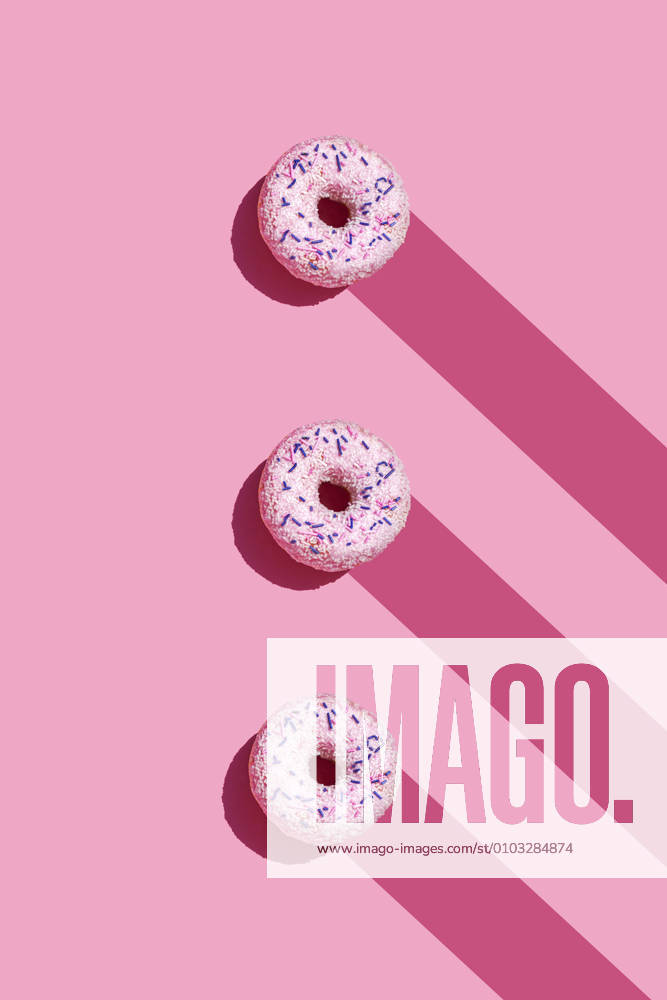 IMAGO Creative, Lifestyle, Barbiecore Studio shot of three sweet doughnuts with sugar sprinkles GEMF04016