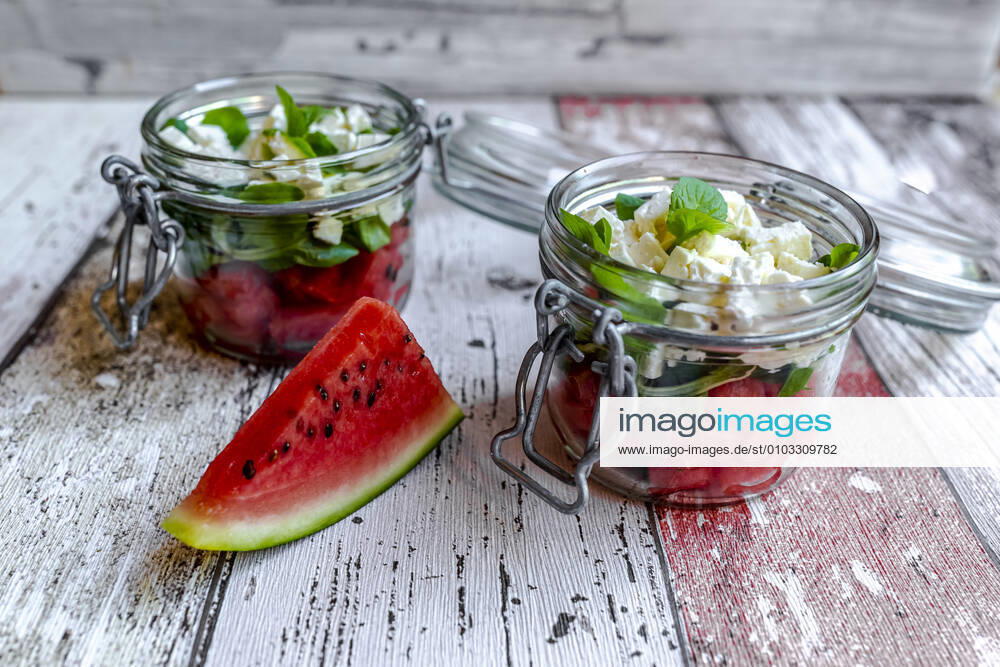 Watermelon slice and jars of watermelon salad with feta cheese, corn salad and mint SARF04607
