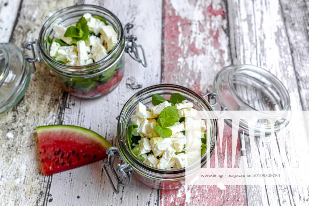 Watermelon slice and jars of watermelon salad with feta cheese, corn salad and mint SARF04608
