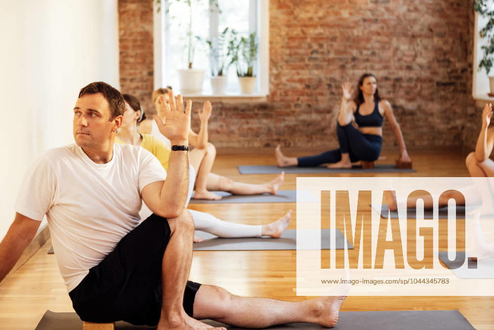 Sporty people of different ages and races practice yoga asanas with instructor in fitness club Sporty people of different ages and races practice yoga asanas with instructor in fitness club. Young multiethnic women and men are sit on mats and stretch in gym with coach. Indoor training. (License=RF) 21476337 ,model released, Symbolfoto