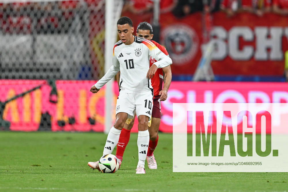 Fussball EM 2024, Schweiz - Deutschland,, v.l. Jamal Musiala (Deutschland, 10), Vincent Sierro (Schweiz, 16) Zweikampf, Duell, Kampf, tackle Frankfurt am Main