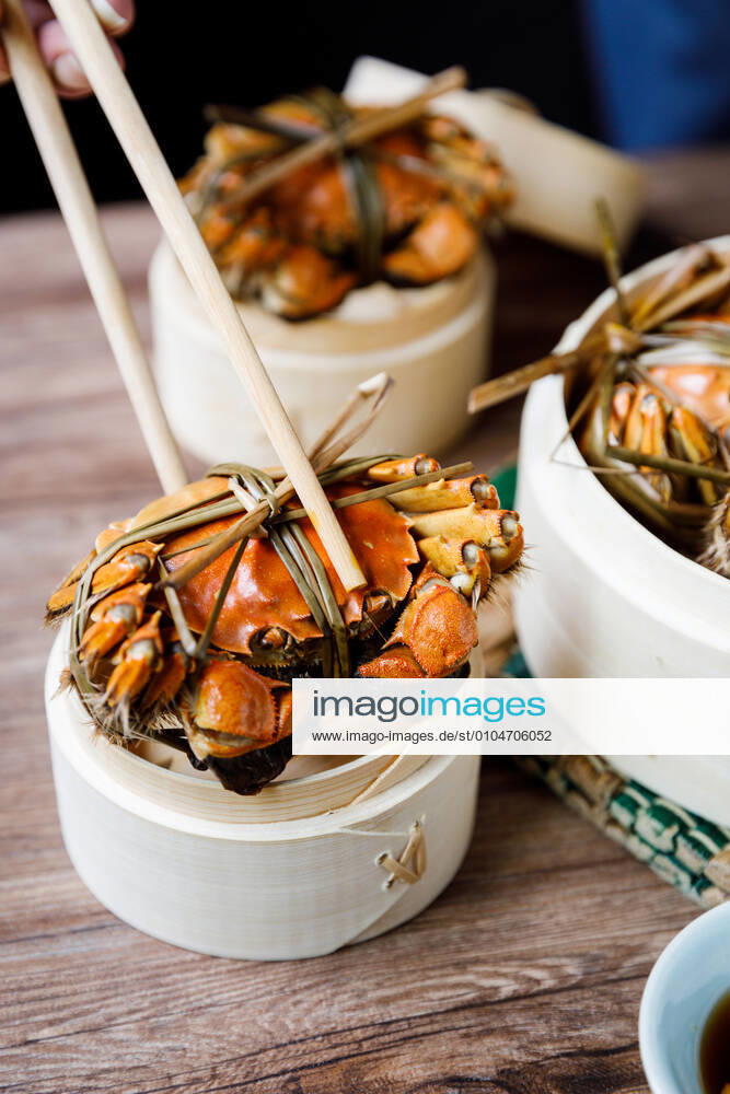 Chinese traditional cuisine in a steamer steamed Yangcheng Lake hairy crabs and seasoned vinegar ginger shreds in a dish. 779640030049599596