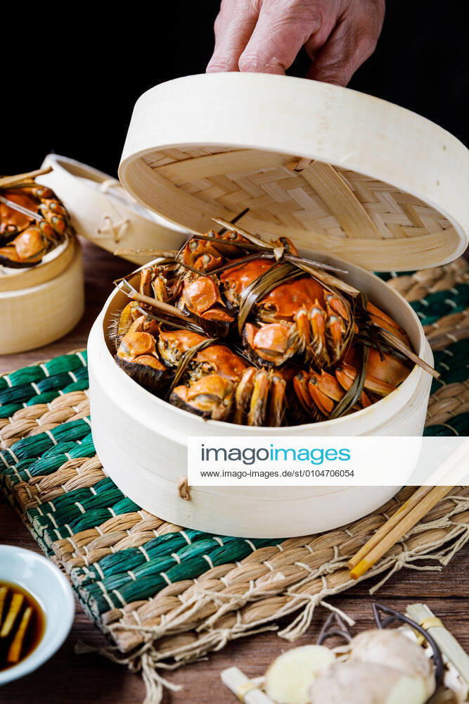 Chinese traditional cuisine in a steamer steamed Yangcheng Lake hairy crabs and seasoned vinegar ginger shreds in a dish. 779640030051041326