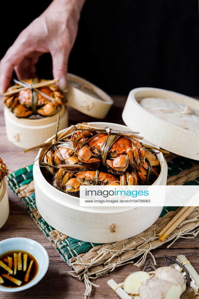 Chinese traditional cuisine in a steamer steamed Yangcheng Lake hairy crabs and seasoned vinegar ginger shreds in a dish. 779640047231959110