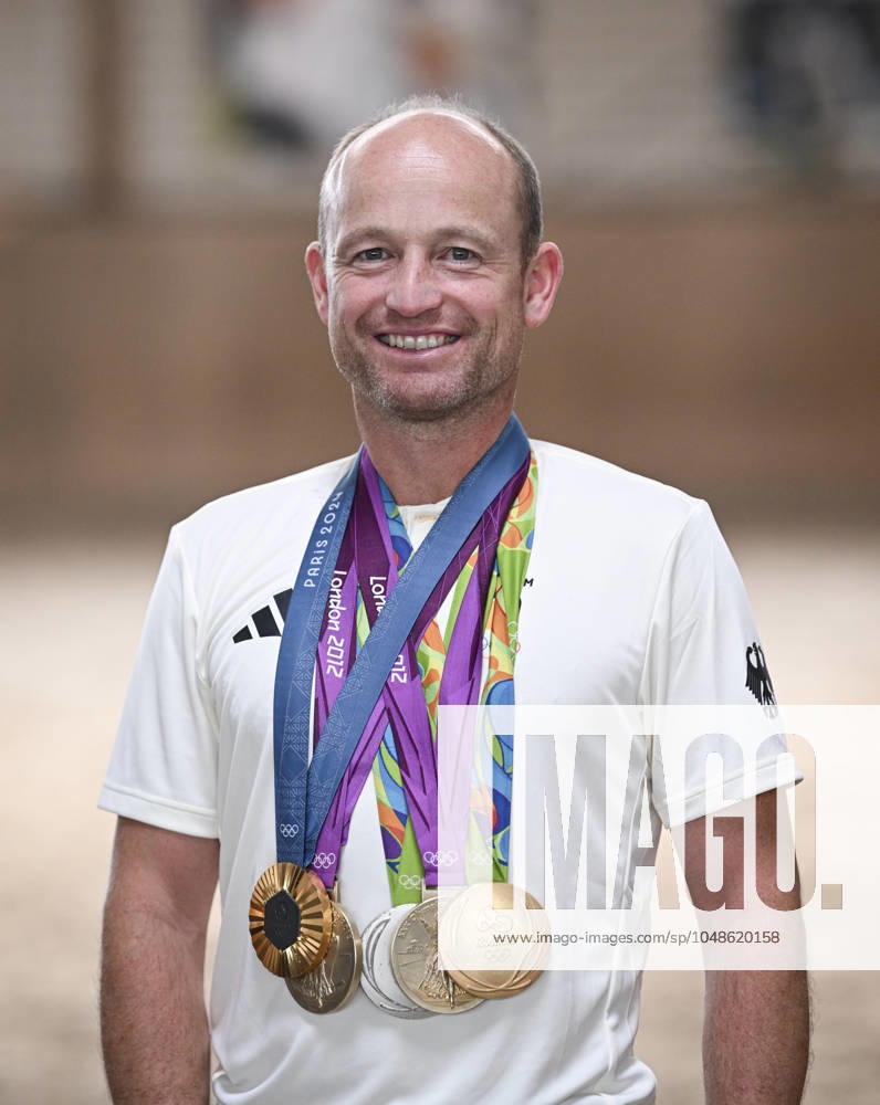 Olympische Sommerspiele in Paris 2024 Reiten Vielseitigkeit 01.08.2024 Fotoshooting mit dem vierfachen Olympiasieger Michael Jung (Deutschland) mit seiner Goldmedaille im Einzel von Paris 2024, sowie die beiden Medaillen, Einzel Gold und Mannschaft Silber von Rio 2016 und den beiden Goldmedaillen der Olympischen Spiele von London 2012 auf seinem Reiterhof in Horb-Altheim (Kreis Freudenstadt)