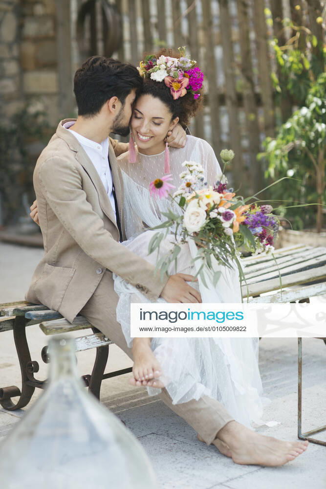 Bride and groom flirting while sitting on bench model released Symbolfoto property released ALBF01486