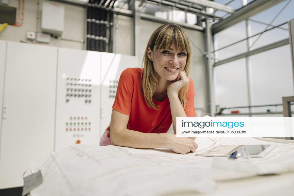Smiling female entrepreneur with hand on chin standing in greenhouse model released Symbolfoto property released JOSEF01776