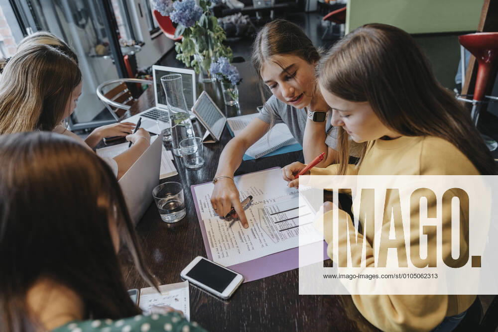 IMAGO Creative: Gesellschaft, Integration Teenage girls studying and learning from home, assisting eachother model released Symbolfoto property released MFF06011