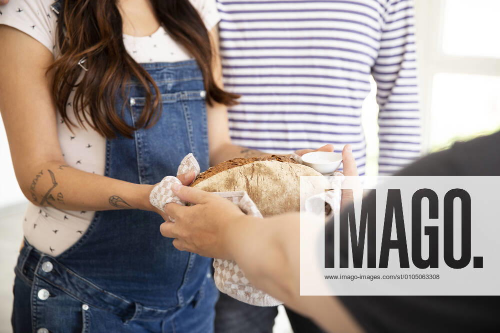 IMAGO Creative: Gesellschaft, Integration Close-up of woman giving bread and salt to new neighbors at home model released Symbolfoto property released MJFKF00570