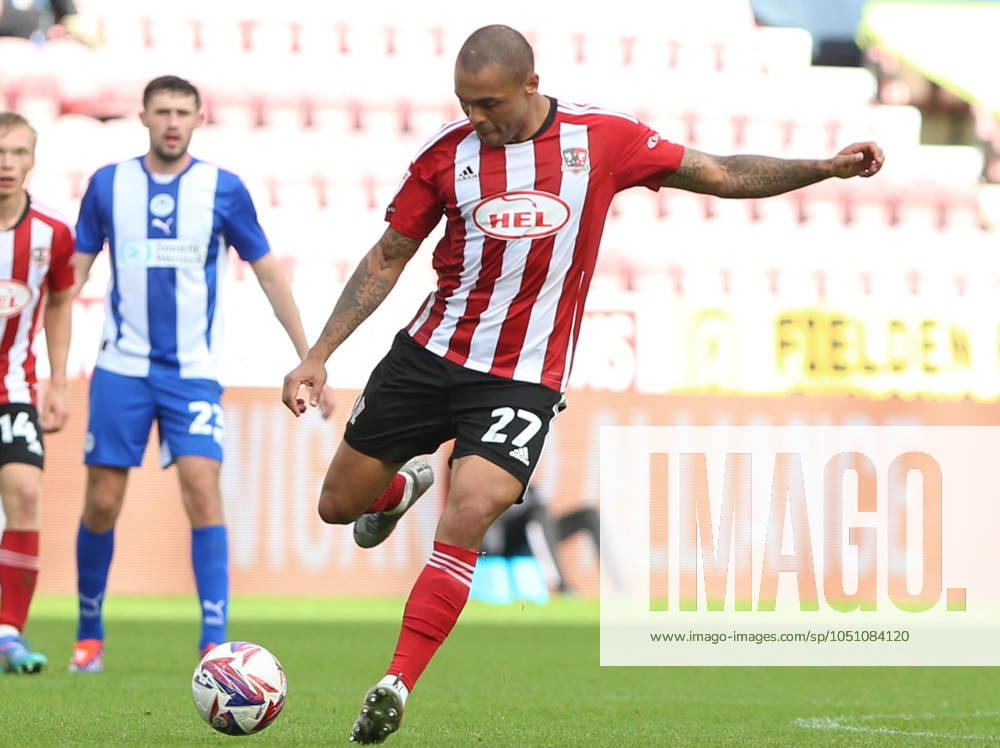 Wigan Athletic v Exeter City EFL Sky Bet League 1 28 09 2024. Exeter City forward Josh Magennis (27) striking the ball during the EFL Sky Bet League 1 match between Wigan Athletic and Exeter City at the Brick Community Stadium, Wigan, England on 28 September 2024. Wigan Brick Community Stadium Greater Manchester England Editorial use only DataCo restrictions apply See www.football-dataco.com ,