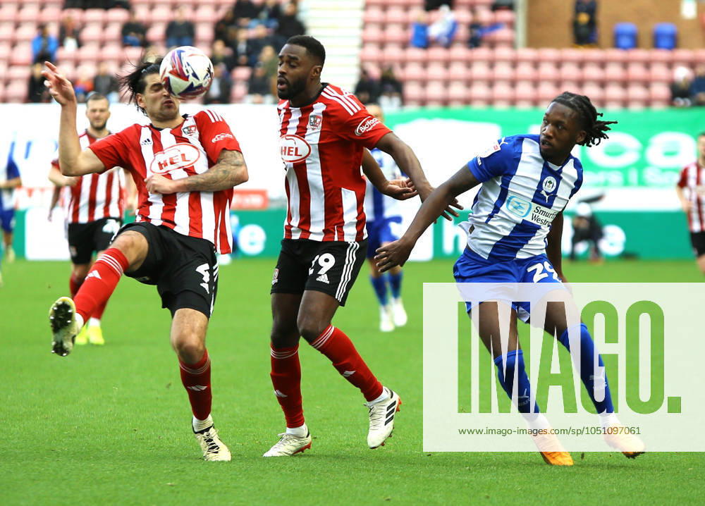 Wigan Athletic v Exeter City EFL Sky Bet League 1 28 09 2024. Exeter City defender Tristan Crama (4) Exeter City (29) and Wigan Athletic forward Silko Thomas (29) tustle for the ball during the EFL Sky Bet League 1 match between Wigan Athletic and Exeter City at the Brick Community Stadium, Wigan, England on 28 September 2024. Wigan Brick Community Stadium Greater Manchester England Editorial use only DataCo restrictions apply See www.football-dataco.com ,