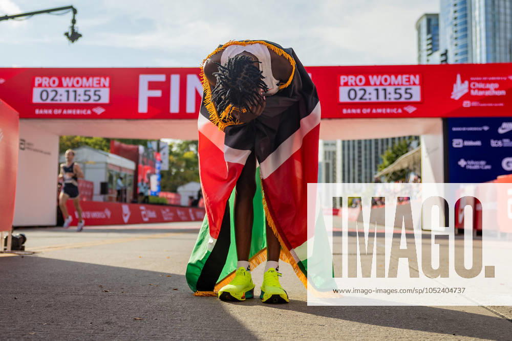 Ruth Chepngetich, from Kenya, lowers her head while wearing the Kenyan flag after crossing the finish line of the Chicago Marathon to win the womenâ€⠢s professional division and break the womenâ€⠢s marathon world record in Grant Park on Oct. 13, 2024, in Chicago. Chicago USA - ZUMAm67_ 0770068775st
