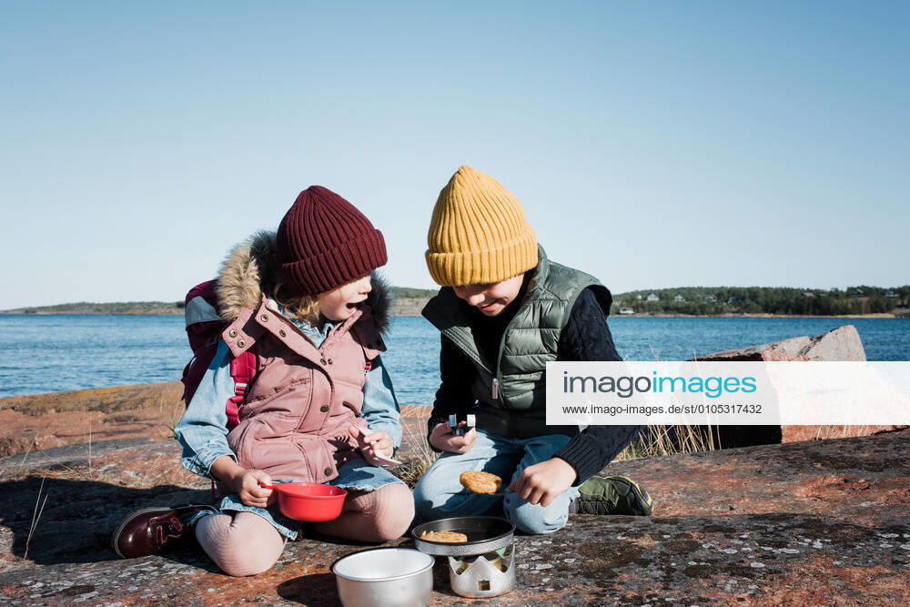 IMAGO Creative: Landleben - Essen siblings hiking cooking food on a travel cooker on a sunny day Äland, Västernorrland County, Sweden CR_RABE200930-511222-01 ,model released, Symbolfoto