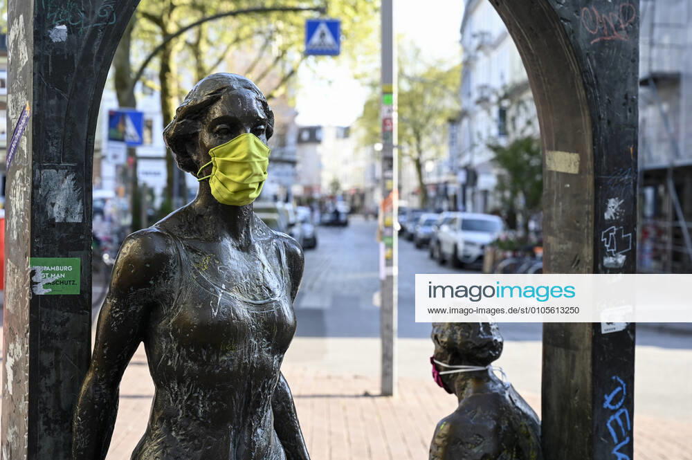 GERMANY, Hamburg, corona virus GERMANY, Hamburg, Ottensen, Corona Virus, COVID-19 , Ottenser Torbogen, two women sculpture by artist Doris Waschk-Balz , somebody has put a protective mask to protect them from Covid-19