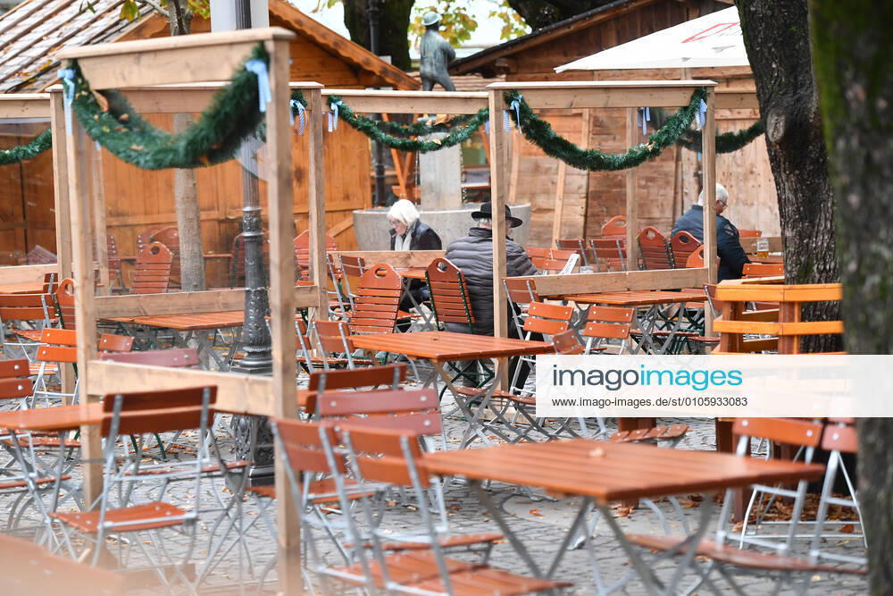 Themenbild: Coronavirus Pandemie Folgen fuer die Gastronomie. Spaerlich besetzte Stuehle und Tische im Aussenbereich eines Biergartens auf dem Viktualienmarkt in Muenchen am 27.10.2020. Zwischen den Tischen stehen Plexiglaswaende zum Schutz der Gaeste. Ab dem 2.November muss wegen dem Lockdown light die Gastronomie geschlossen bleiben, Schliessung-Folge der Corona Pandemie,Lockdown,Shutdown,Inzidenzwert.