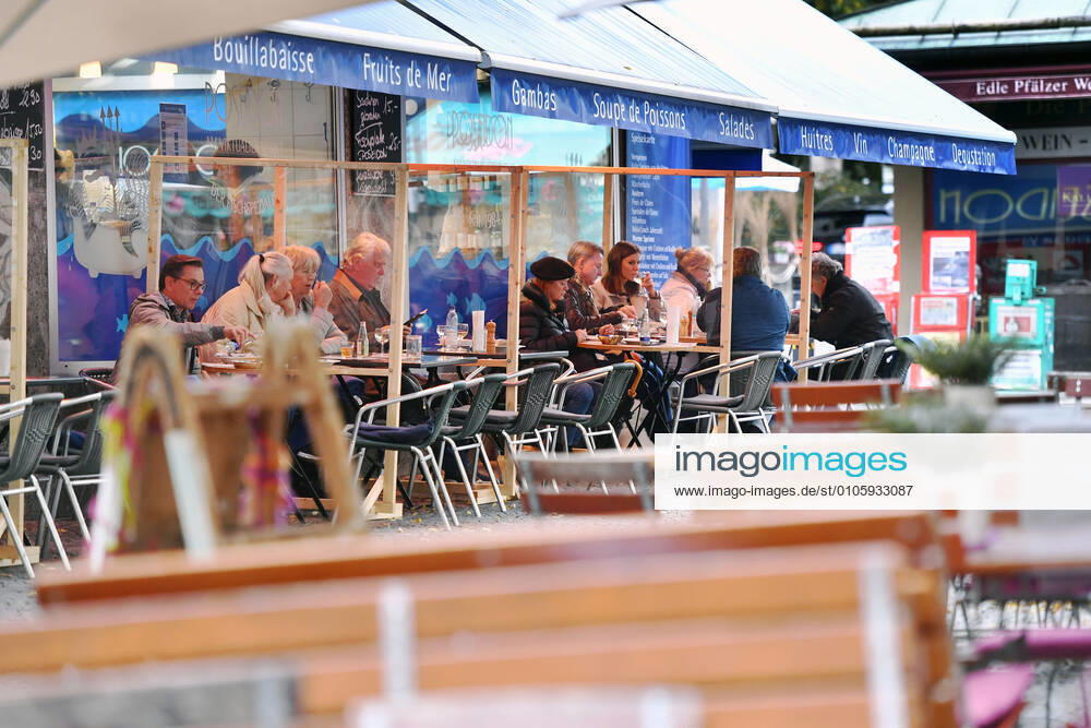 Themenbild: Coronavirus Pandemie Folgen fuer die Gastronomie. Gaeste sitzen im Aussenbereich eines Fisch Restaurants in der Innenstadt von Muenchen am 27.10.2020. Zwischen den Tischen stehen Plexiglaswaende zum Schutz der Gaeste vor dem Coroanvirus, Ab dem 2.November muss wegen dem Lockdown light die Gastronomie geschlossen bleiben, Schliessung-Folge der Corona Pandemie,Lockdown,Shutdown,Inzidenzwert.