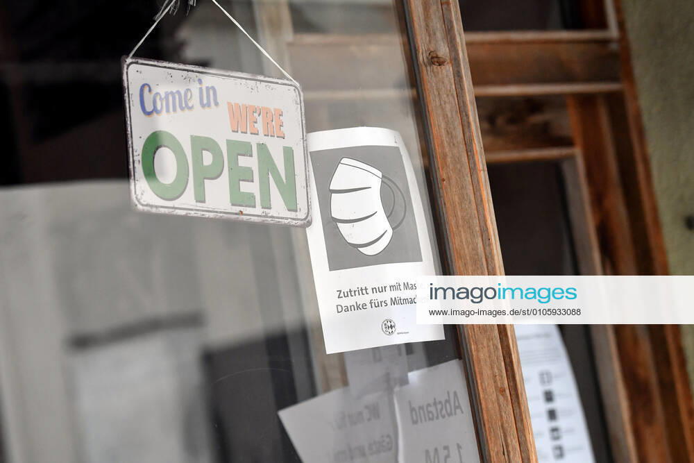 Themenbild: Coronavirus Pandemie Folgen fuer die Gastronomie. Hinweis Betreten nur mit Mundschutz,Maske , Come in- we are open,wir haben geoffnet am Eingang zu einer Bar,Kneipe in Muenchen am 27.10.2020. Ab dem 2.November muss wegen dem Lockdown light die Gastronomie geschlossen bleiben, Schliessung-Folge der Corona Pandemie,Lockdown,Shutdown,Inzidenzwert.