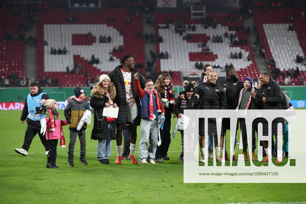 Fussball DFB Pokal 1 4 Finale, RB Leipzig - VfL Wolfsburg, v.l. El Chadaille Bitshiabu (Leipzig, 5), Xavi Simons (Leipzig, 10), Lutsharel Geertruida (Leipzig, 3) und Lois Openda (Leipzig, 11) feiern mit Kindern, Jubel ueber den Sieg, Jubel nach Spielende Leipzig