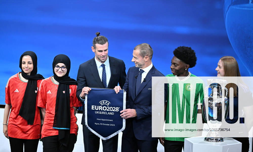 Ireland and United Kingdom confirmed to co-host 2028 UEFA European Football Championship GENEVA, SWITZERLAND - OCTOBER 10: UEFA President Aleksander Ceferin (3rd R) and Welsh retired professional footballer, heading the delegation of UK and Ireland Gareth Bale (3rd L) hold the pennant as they pose with the pennant next to the trophy after United Kingdom and Ireland were elected to host the Euro 2028 football tournament during a ceremony held after the Executive Board meeting at the UEFA headquarters in Nyon, Geneva, Switzerland on October 10, 2023. Geneve Isviçre. Editorial use only. Please get in touch for any other usage.