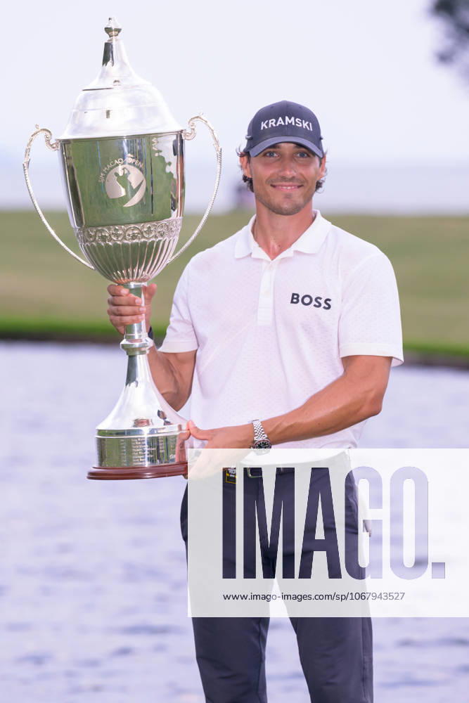Macau Open Golf , Final Round, Macau Golf and Country Club Coloane, Macao, China . Germanyâ€⠢s Dominic Foos Wins the Macau Open Golf after a tiebreaker with Taiwans Wang, Wei-hsuan. Foos holds the cup by the lake on the 18th fairway. Macao China - ZUMAr144 20251019_zap_r144_009