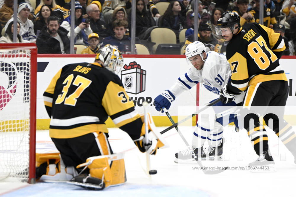 Pittsburgh Penguins goaltender Arturs Silovs (37) bats the puck away as Pittsburgh Penguins center Sidney Crosby (87) applies pressure to Toronto Maple Leafs center John Tavares (91) during the first period at PPG Paints Arena in Pittsburgh on Saturday, November 29, 2025. PIT2025112904 ARCHIExCARPENTER
